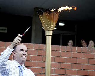 MADELYN P. HASTINGS | THE VINDICATOR..John McNally lights the torch during the Community Cup opening ceremonies at the Central YMCA in downtown Youngstown on Friday, August 9, 2013.... - -30-..