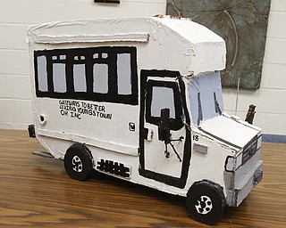 ROBERT K. YOSAY | THE VINDICATOR..using cardboard glue and tape Logan has made a replica of the bus used to transport the students at Gateway..Logan, a young adult at Gateways to Better Living, is considered by staff members to be a noteworthy artist ....... - -30-..