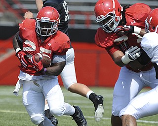 Youngstown State running back #25 Torrian Pace runs the football behind the black of offensive linemen #71 Kyle Bryant during a scrimmage on August 10, 2013.