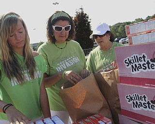 Audrey Dearing (15) of New Middletown, Reba Soldressen of Struthers, and Cathleen Smail of Campbell help pack bags full of groceries during the Goodness Invasion at the Covlli Centre on Saturday Morning. Dustin Livesay | The Vindicator 8/10/13 Covelli Centre.