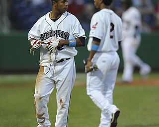 Scrappers base runner #6 Joel Mejia taks off his batting gloves after being picked off at first base to end the bottom of the 4th inning during a game between the Scrappers and Renegades on August 10, 2013. First base coach #2 Robel Garcia pictured.