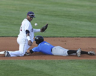 Scrappers infielder #12 Claudio Bautista can not field the throw front he catcher while Renegades base runner #1 Johnny Field steals second base int he top of the 4th inning during a game between the Scrappers and Renegades on August 1, 2013.