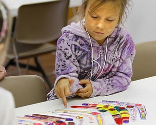 Zoey Schineiter, 8, of Austintown ponders the designs on boomerangs she and other children decorated as part of AgVenture Camp.