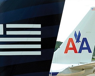A US Airways plane, foreground, and an American Airlines plane are seen parked at the terminal at Washington’s Ronald Reagan National Airport on Tuesday. The Justice Department and a number of U.S. state attorneys general Tuesday challenged a proposed $11 billion merger between US Airways Group Inc. and American
Airlines’ parent company, AMR Corp.