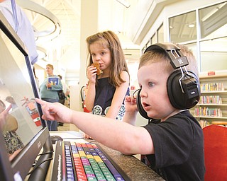 Beckett Liller, 2, and his sister, Harper Liller, 5, examine a computer during Tuesday’s dedication of the new $2 million Tri-Lakes Library, 13820 Mahoning Ave., North Jackson. They are the grandchildren of Anne Liller, the library system’s manager of urban branches and community outreach. The dedication ceremony was followed by the Outback Ray live animal show.