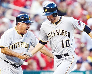 Pittsburgh Pirates’ Jordy Mercer, right, is congratulated by third base coach Nick Leyva after hitting a solo home run during the second inning of a game against the St. Louis Cardinals on Tuesday in St. Louis. The game was not completed in time for this edition.