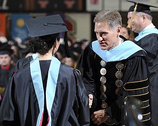 Youngstown State president Randy Dunn shakes the hand of a student after she received her masters degree during the summer commencement ceremony Saturday morning at Beeghley Center.