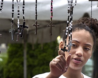 Kelli Cardinal/The Vindicator
Iliana (ok) Rojas, 14, from Loraine, looks at a hand-made rosary Sunday during the Spanish Heritage Festival in downtown Youngstown. Rojas was visiting the festival with her sister and grandparents.