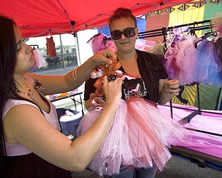 Kelli Cardinal/The Vindicator
Sarah Rodriguez, left, from Boardman, shows a tutu Sunday to Ashley Zelaya, from Warren, who was looking for a size to fit her 9-month-old daughter, Adrianna, during the Spanish Heritage Festival in downtown Youngstown. Rodriguez runs her business "Tutu Beauties" out of her home in Boardman.