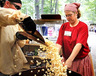 MADELYN P. HASTINGS | THE VINDICATOR
(L-R) Mike Olson and Melissa McKinney make popcorn at the Original Kettle Corn booth at the Shaker Woods Festival in Columbiana on Sunday, August 18, 2013.