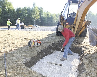 Workers with Miller-Yount Paving of Bazetta, including Curtis Jones
in the foreground are shown completing parking lot and drainage work
at the new Eastlake MetroPark being created on state Route 46 just
north of Lake Vista retirement community in Cortland. The first phase
of the park will include a sled riding hill to be ready this winter.