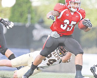 YSU’s Jamaine Cook (35) drags Valparaiso’s Patrick Derbek (24) during a Youngstown State game last season at
Stambaugh Stadium. Cook has returned to the Cleveland Browns after being cut in May.