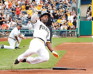 Pirates baserunner Andrew McCutchen slides home as he scores from first on a double by Russell Martin in the
first inning of Sunday’s game against the Diamondbacks at PNC Park in Pittsburgh.