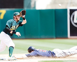 Indians baserunner Jason Kipnis, right, steals second base as Athletics second baseman Eric Sogard awaits the throw during Sunday’s game in Oakland, Calif. The Athletics won, 7-3.