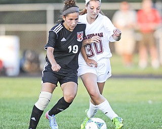 Canfield’s Paige Bidinotto, left, and Boardman’s Megan O’Neil battle for a ball toward midfield during the first half of Monday’s game at Boardman High.