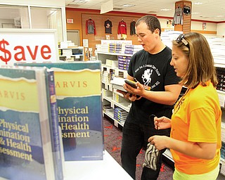 Kevin Casey of New Jersey and Alana Lesnanski of Boardman shop for textbooks Tuesday at the Youngstown State University Bookstore. Classes begin today .