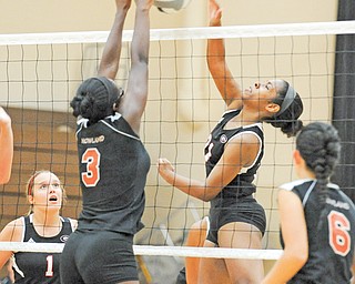 Girard’s Alasjia Dykes, right, goes up for a spike as Howland’s Kayla Manningham (3) attempts a block during a match Tuesday night a match at Howland High. Girard’s Melanie Bakes (1) and Howland’s Jessie Moore (6)
watch. The Tigers outlasted the Indians in five games.