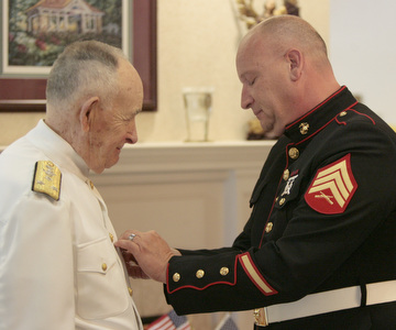 Sgt. Thomas P. Smith pins Admiral Kenneth Monroe during Crossroads Hospice service honoring vets at Windsor House at Liberty Arms.