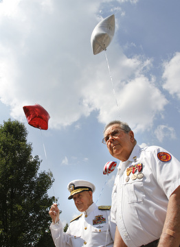 Admiral Kenneth Monroe Carr and Glenn Buzzard of Hubbard watch as star-shaped balloons are released during a service  at Windsor House at Liberty Arms to honor World War II veterans who never came home. 