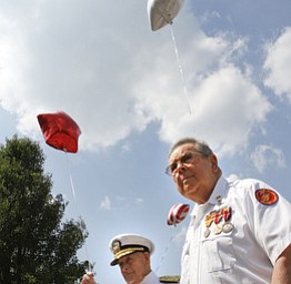 Admiral Kenneth Monroe Carr and Glenn Buzzard of Hubbard watch as star-shaped balloons are released during a service at Windsor House at Liberty Arms to honor World War II veterans who never came home.