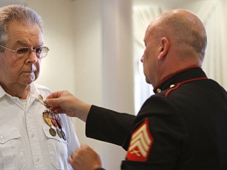 Marine Sgt. Thomas P. Smith pins Glenn Buzzard of Hubbard during Crossroads Hospice's service honoring vets at Windsor House at Liberty Arms.