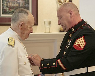 Sgt. Thomas P. Smith pins Admiral Kenneth Monroe during Crossroads Hospice service honoring vets at Windsor House at Liberty Arms.
