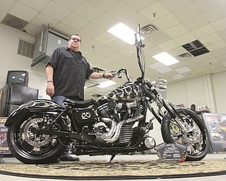 William D. Lewis\The Vindicator Dave Cook, owner of Sledgehammer Bobbers, poses with a custom motorcycle he built. His business is building an Evil Knievel tribute motorcycle..