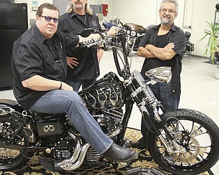 William D. Lewis\The Vindicator Dave Cook, left, owner of Sledgehammer Bobbers, poses with a custom motorcycle he built. His business, located in Howland, is building an Evil Knievel tribute motorcycle. With him are Dennis Markle, center, bike handler and detailer and George Beharry, head mechanic. William D. Lewis\The Vindicator.