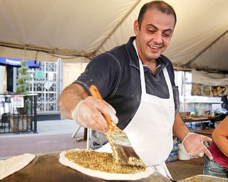 MADELYN P. HASTINGS | THE VINDICATOR..Elie Aboutouma of Lakewood makes a meat pie in the Oasis Bakery tent at the Arab American Community Festival in downtown Youngstown on Saturday, August 24, 2013.... - -30-..