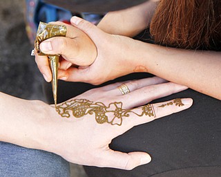 MADELYN P. HASTINGS | THE VINDICATOR..Lamia Sassya of Boardman and 'Henna by Lamia' paints a henna tattoo on Dagmara Apaeva of Canfield at the Arab American Community Festival in downtown Youngstown on Saturday, August 24, 2013.... - -30-..