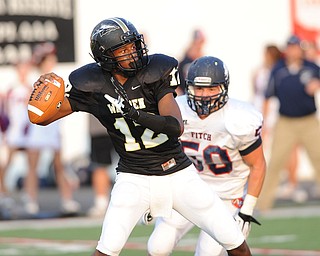 Harding quarterback #12 Hasan Muhammad drops back to pass while under pressure from Fitch linebacker #50 Ryan Sayers during the first quarter during a game on Friday August 30, 2013.