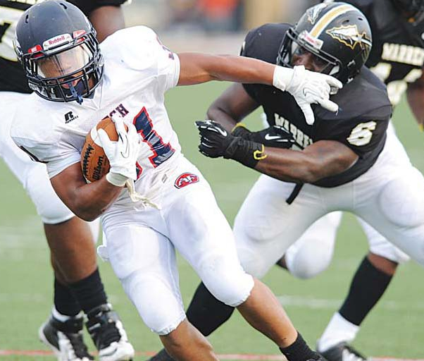 Austintown Fitch running back Tyler Hewlett (31) escapes the grasp of Warren Harding linebacker John Coleman (6) during the ﬁrst quarter Friday night at Mollenkopf Stadium in Warren. The Falcons overwhelmed the Raiders, 48-0.