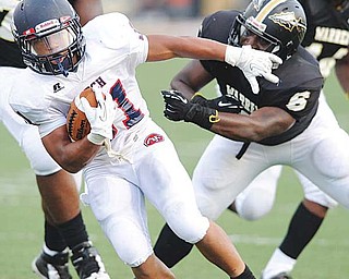 Austintown Fitch running back Tyler Hewlett (31) escapes the grasp of Warren Harding linebacker John Coleman (6) during the first quarter Friday night at Mollenkopf Stadium in Warren. The Falcons overwhelmed the Raiders, 48-0.