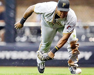 The Pittsburgh Pirates’ Marlon Byrd can’t come up with a ball hit by Milwaukee Brewers’ Jean Segura during the 
first inning of a game Tuesday in Milwaukee.