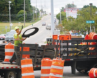 A worker sets up construction barrels along U.S. Route 224 and Hillside Drive in Canfield on Tuesday. The Ohio Department of Transportation will be resurfacing the road along 224 to Talsman Drive. The project should end in late October.