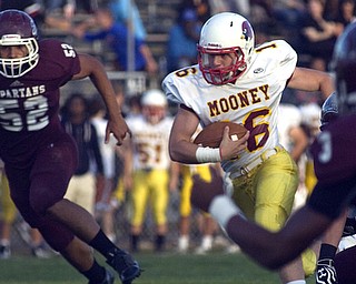 Kelli Cardinal/The Vindicator.Cardinal Mooney quarterback Jon Saadey finds a break in the line Friday night against Boardman defender Alex Birchfield at Boardman.