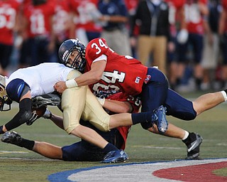 Hoban #3 is drug down by Fitch defenders #34 Sam Ortz and #50 Ryan Sayers on a speed sweep play early in the first quarter of a game on Friday September 6, 2013.