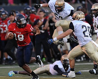 Fitch #18 Antwan Harris prepares to stiff arm Hoban defender #28 Joe Parisi after sprinting past a hurdling #52 Max Zoldesy during the first quarter of a game on Friday September 6, 2013.
