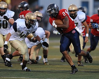 Fitch #24 Darrin Hall runs the football while Hoban definer #44 Dane Kersh attempts to go for the tackle in the first quarter of a game on Friday September 6, 2013.