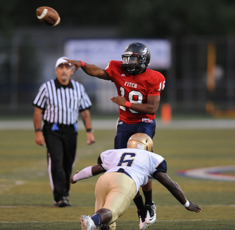 Fitch #18 Antwan Harris throws a pass out into the flat while avoid pressure from a diving Hoban #6 D'Angelo James in the first half of a game on Friday September 6, 2013.