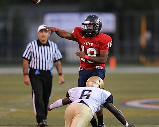 Fitch #18 Antwan Harris throws a pass out into the flat while avoid pressure from a diving Hoban #6 D'Angelo James in the first half of a game on Friday September 6, 2013.