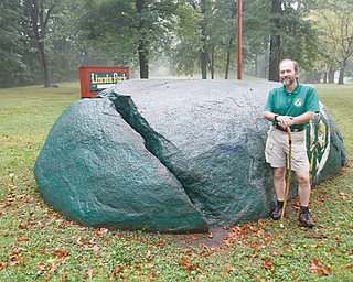 Mill Creek Park naturalist Ray Novotny stands next to Council Rock in Lincoln Park on Youngstown’s East Side. Novotny will lead a hike Sunday in the Dry Run creek gorge from the park to the Lake McKelvey dam and back. Legend has it that hundreds of Native Americans who had gathered for a conference at the rock in 1755 were killed by a lightning strike that split the granite rock.