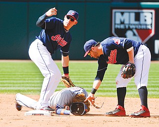 The Indians’ Asdrubal Cabrera waves for help as Jason Kipnis picks up the helmet of Mets base runner Justin
Turner, who lays on the ground after being tagged out in the face on a steal attempt in the sixth inning of
Sunday’s game in Cleveland. Turner was injured on the play but finished the game, which ended with the Mets winning 2-1.