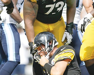 Steelers guard Ramon Foster helps up QB Ben Roethlisberger after he was tackled in the third quarter of their season opener against the Titans in Pittsburgh. Roethlisberger was sacked five times in the Steelers’ 16-9 loss
