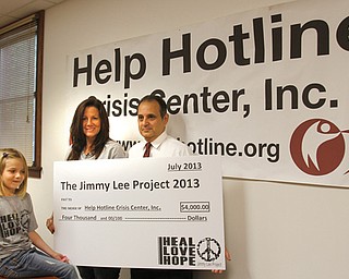 The Jimmy Lee Project presented a $4,000 check Monday to Help Hotline Crisis Center’s suicide prevention and intervention program in memory of James “Jimmy Lee” Gruhlkey, who committed suicide March 2, 2011. From left are Genaviene Mayhew, 6, of Struthers, Jimmy Lee’s daughter; Pamela Rocco of Stoutsville, Ohio, his
mother; and Duane Piccirilli, Help Hotline chief executive director.