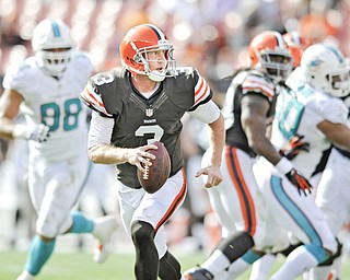 Cleveland Browns quarterback Brandon Weeden runs from the Miami Dolphins pass rush in the fourth quarter
of a game Sunday in Cleveland. Weeden was sacked five times in a 23-10 loss to Miami.