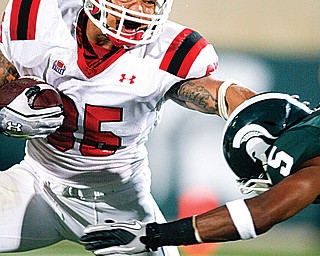 Youngstown State’s Jamaine Cook, left, stiff -arms Michigan State’s Johnny Adams during a game in East Lansing,
Mich. Michigan State won, 28-6. The teams will meet again Saturday in East Lansing.