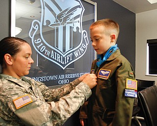 Pvt. Brandi Burrows with the Army makes sure her brother, Mason Burrows, 9, of Mineral Ridge, looks the part of a second lieutenant in the 910th Airlift Wing at the Youngstown Air Reserve Station in Vienna. Mason was the air reserve station’s Pilot for a Day on Wednesday. The program provides a day of activities to children with chronic or life-threatening disease or illness.