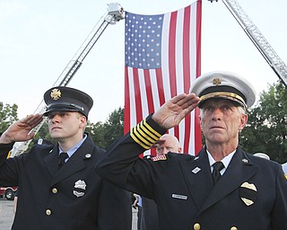 Ellsworth Township firefighter Jeremy Hartman, left, and Ellsworth Fire Department Chief Sherman Yeager salute during the 9/11 ceremony at the Austintown 9/11 Memorial Park.