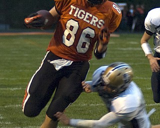 Kelli Cardinal/The Vindicator .Springfield ball carrier Mark Schuler avoids the tackle Friday night by Lowellville defender Eric Grow at Springfield High School.